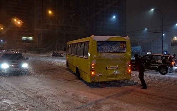 Кияни виштовхують автобуси, які застрягли на засніженій дорозі