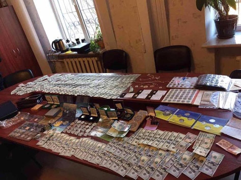 На Сумщині у начальника поліції знайшли арсенал зброї, золоті злитки та прапор Росії