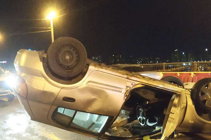 На мосту Патона п’яна водійка Nissan влетіла в огорожу і перекинулась (фото, відео)