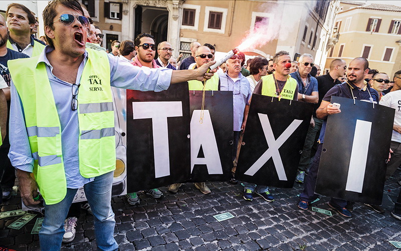 Итальянский таксист поджег фаер во время акции протеста против сервиса Uber в Риме, Италия, 10 сентября 2015 года. Сотни итальянских водителей такси вышли на улицы Рима в знак протеста против проекта закона в пользу сервиса UberPOP. 
