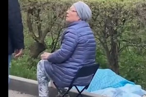 Жінка сидить біля тіла вботої росіянами матері. Київ, 24 квітня 2025 року