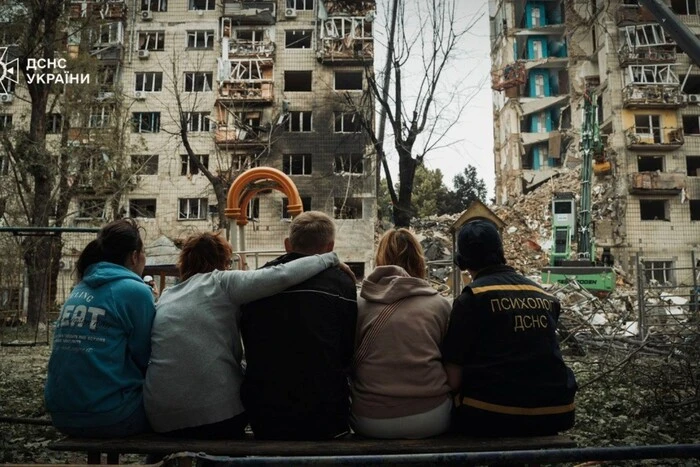 Київ: подружжя сидить біля зруйнованого будинку, під завалами їх син
