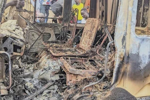 Люди зібралися навколо обвуглених залишків згорілого автомобіля після смертельного нападу в Команді, провінція Ітурі на сході Конго