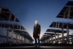 Джон Сандаскі стоїть у полі геліостатів на Національному випробувальному центрі сонячної теплової енергії