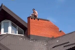 У Києві чоловік з ножем виліз на дах будинку біля авторинку (відео)