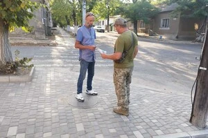 Чоловік отримує розʼяснення від представника ТЦК в одному з інформаційних пунктів у Одесі