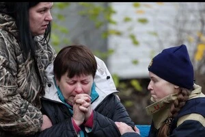 Жінка втратила близьку людину після обстрілу. Кадри з Києва, які розривають серце