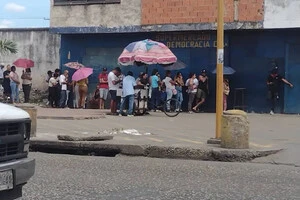 Люди стоять у черзі, щоб придбати продукти у Каракасі