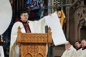 Настоятель Римсько-католицької парафiї св. Миколая у Києвi отець Павло Вишковський демонструє парафіянам документ про передачу храму