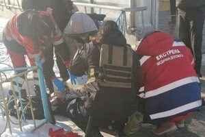 Лікарі надають допомогу чоловікові, який послизнувся та впав на слизькій дорозі у Києві біля одного з виходів зі станції метро «Оболонь» 