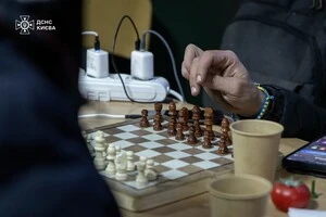 Кияни грають у шахи в одному з пунктів обігріву у столиці після масованого обстрілу РФ