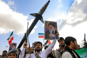 Мужчина держит фото верховного лидера Али Хаменеи во время митинга памяти. Сана (Йемен), 1 марта 2026 года