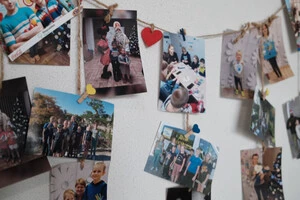 Фотографії дітей, врятованих організацією «Врятуй Україну», виставлені в офісі групи