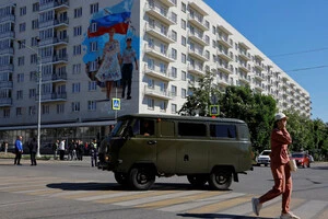 Мурал, прикрашений на будівлі, присвячений взяттю Росією Маріуполя, височіє над мешканцями окупованого українського міста 