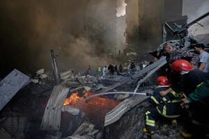 Пожежники намагаються загасити полум'я на місці авіаудару, який у середу зруйнував багатоквартирний будинок у Бейруті