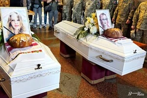 Дві білі труни із світлинами сестер Віри та Любави Яковлєвих та букетами квітів у Михайлівському Золотоверхому