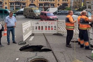 Комунальники оглядають провал асфальтового покриття біля Бессарабського ринку