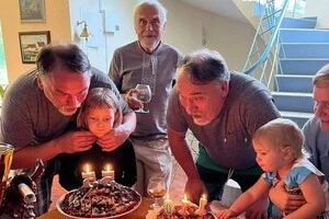 Брати Капранови з онуками відзначають спільний ювілеї три роки тому. Позаду письменників стоїть їхній батько