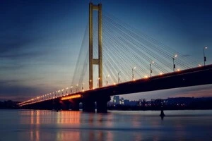 Вантовий однопілонний міст перетинає річку Дніпро, з'єднуючи правий і лівий береги Києва   