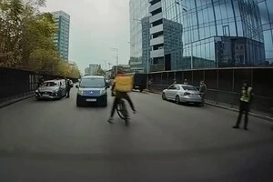 Велисипедист, ухилившись від поліцейського, ледь не потрапив під колеса автівки