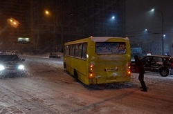 Кияни виштовхують автобуси, які застрягли на засніженій дорозі