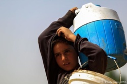 Сирійський хлопчик несе воду