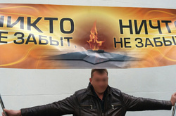 Учасник акції «Ніхто не забутий, ніщо не забуте» намагався розгорнути банер із фоном кольорів «георгіївської стрічки»