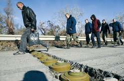 Люди переступають через міни