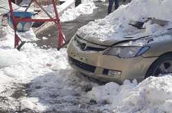 Бурулі падають на автомобілі, припарковані на вулицях Києва