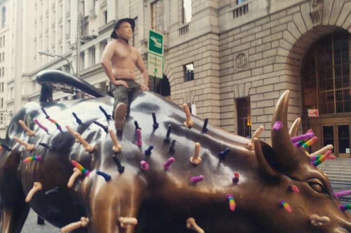 Статую быка в Нью-Йорке оседлал человек в маске Путина с фаллоимитаторами