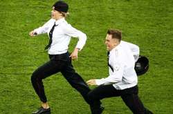  Четверо учасників гурту Pussy Riot, переодягнені в міліцейську форму, вибігли на поле під час фінального матчу Чемпіонату світу з футболу 