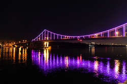 У вівторок пішохідний міст у Києві засяяв фіолетовим кольором (фото, відео)