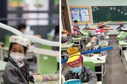 В Китае школьников заставляют носить смешные шляпы, чтобы научить их держать дистанцию