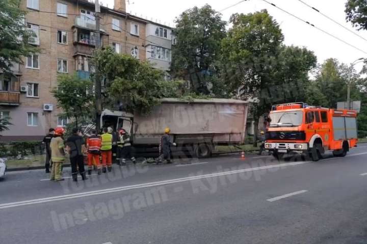 У Києві вантажівка врізалась у стовп: водія затисло в кабіні (відео)