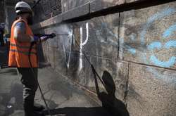 Комунальники допомогають активістам відмивати стіни від графіті