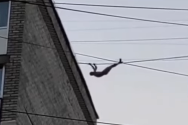У Миколаєві оголений чоловік прогулювався дахами будинків, перебираючись по дроту (відео)