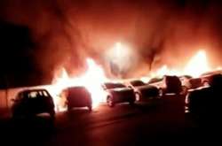 Охоплені вогнем автівки під час протестів у місті Лод