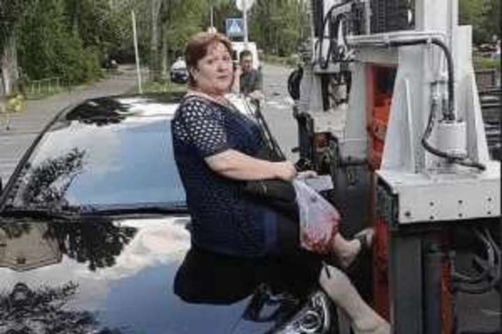 У Києві жінка вилізла на авто, щоб його не евакуювали (відео)