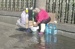 Біля столичного вокзалу жінка влаштувала прання на тротуарі (відео)