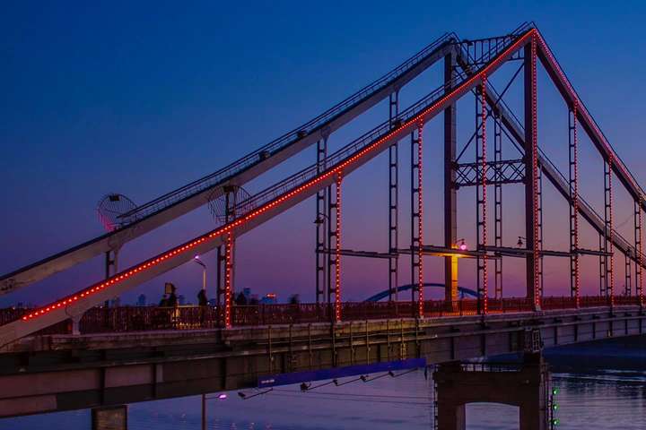 Пішохідний міст у Києві засвітився червоним кольором (фото)