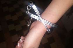 Дівчина одягнула собі на руку металеві браслети