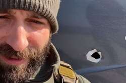 Телеведущий на фоне обстрелянной машины