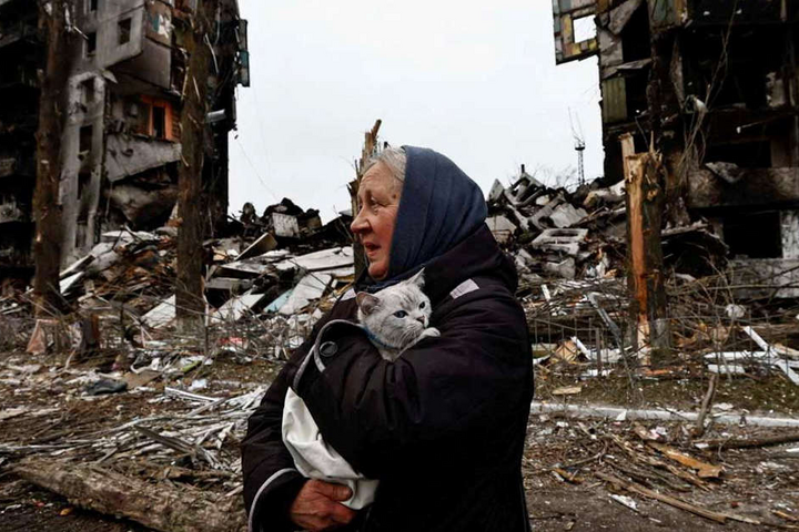 Женщина ждет, пока из-под завалов вытащат семью. Жуткое фото из Бородянки