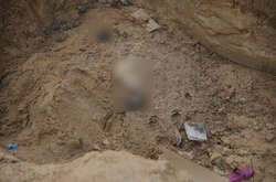 Комунальники поховали закатованих окупантами мешканців Бучі у великій могилі біля храму