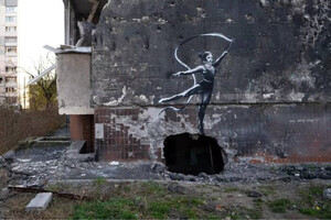 На руинах разбомбленного здания в Бородянке изображена гимнастка, которая выполняет стойку на руках