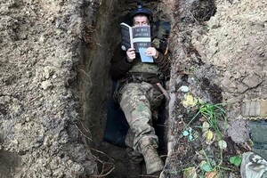Українців вразило фото військового, який читає в окопі 