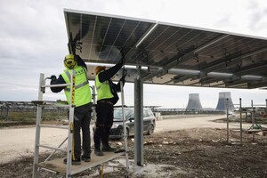 Двоє робітників встановлюють двосторонню сонячну панель потужністю 540 Вт у парку сонячних панелей у Тріно, Італія