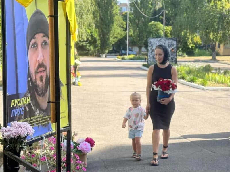 Дружина з донечкою несуть квіти Герою України Руслану Прусу
