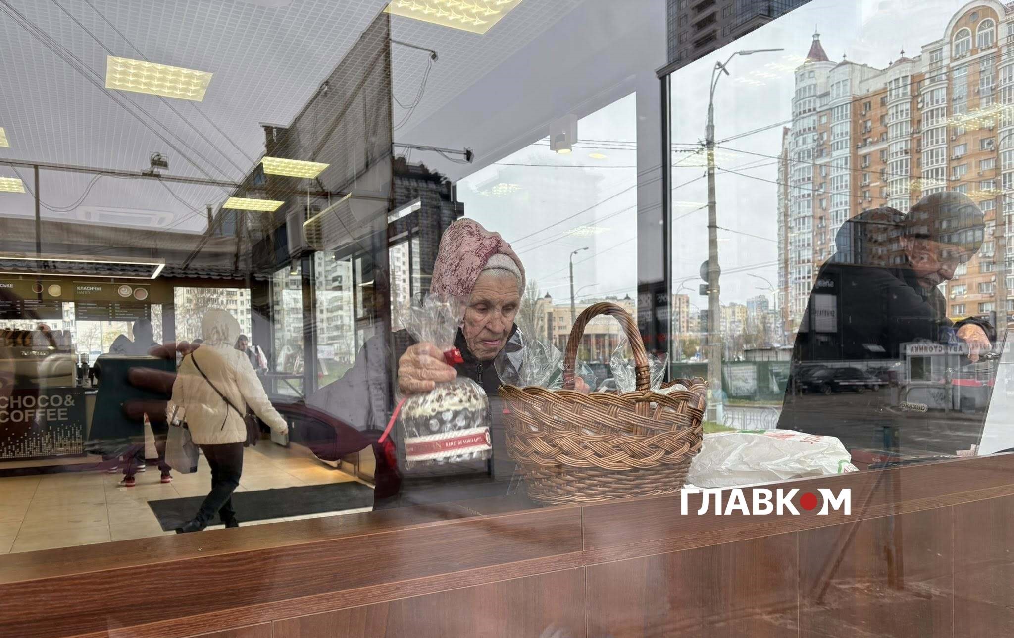 Жінка дбайливо вкладає впольовану паску у великодній кошик
