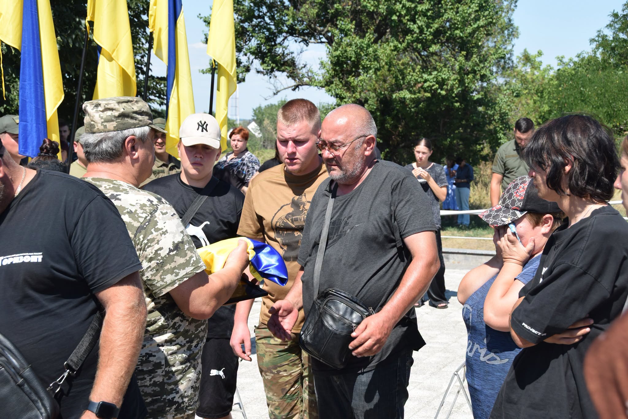Тато захисника приймає з рук військових прапор України